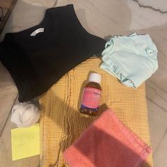 Cousas de bebé baby blanket, clothes and a cream/oil., segundo informou Conscious Hotel Museum Square usando iLost