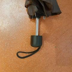 Ombrello pieghevole marron, come riportato da TCL utilizzando iLost