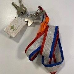 Nøkkelring Met rood wit blauwe hanger, som rapportert av Gemeente Ede ved bruk av iLost