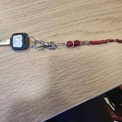 Sleutel met met kralen ketting rood, as reported to iLost