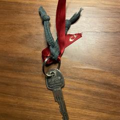 Sleutel groen touw met rood lint, come riportato a iLost