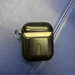 Apple AirPods in een zwart hoesje, iLost-i jakinarazi zaion moduan