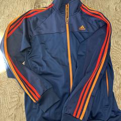 Blauw Adidas jasje met oranje strepen, iLost'a bildirildiği gibi