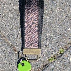 Sleutel met zebra-polsband en groene keyfob, som rapportert til iLost