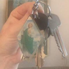 set of keys on key holder with christian figure, come riportato a iLost