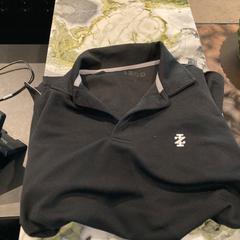 Polo Zwarte kleur van het merk IZOD, come riportato da Van der Valk Hotel Heerlen utilizzando iLost