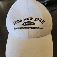 Boné wit petje met zwarte opdruk: 1989 New York, como reportado por Universiteit Gent - Faculteitsbibliotheek LW utilizando o iLost