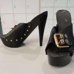 Sabates Hout, zwart met goudkleurige gespen, segons ha informat H’ART Museum mitjançant iLost