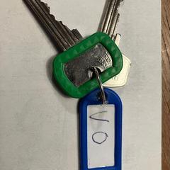 bosje met 2 huissleutels en blauwe hanger tekst VO, amint azt az iLostnak jelentették.