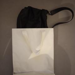 zwarte schoudertas in witte papieren tas, iLost에 보고됨