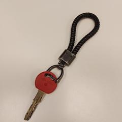 Sleutel rood met zwart hangertje, zoals gemeld door Gemeente Zonhoven met iLost