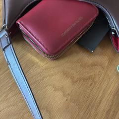 Hand tas bruin met rode portemonnee, amint azt az iLostnak jelentették.