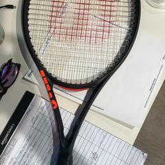 Tennis racket black color, Wilson in red, as reported by Cincinnati Tennis LLC using iLost