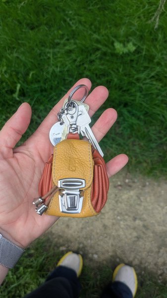 Keychain Met leren tasje oranje/geel en een ronde hanger eraan