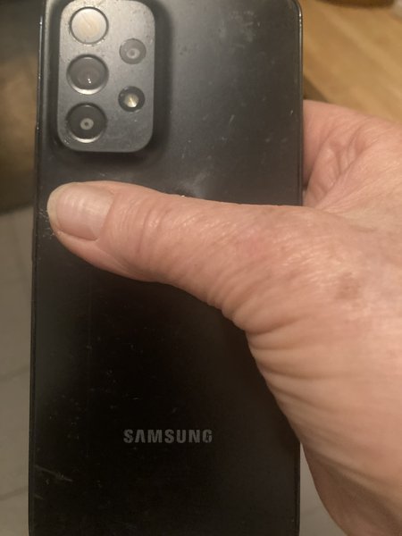 Samsung smartphone Zwart met kenmerk beschadiging achterkant onder mijn duim  