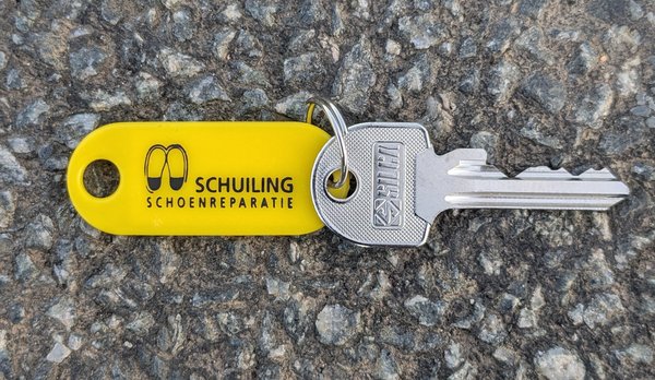 Sleutel sleutel met geel label van Schuiling schoenreparatie